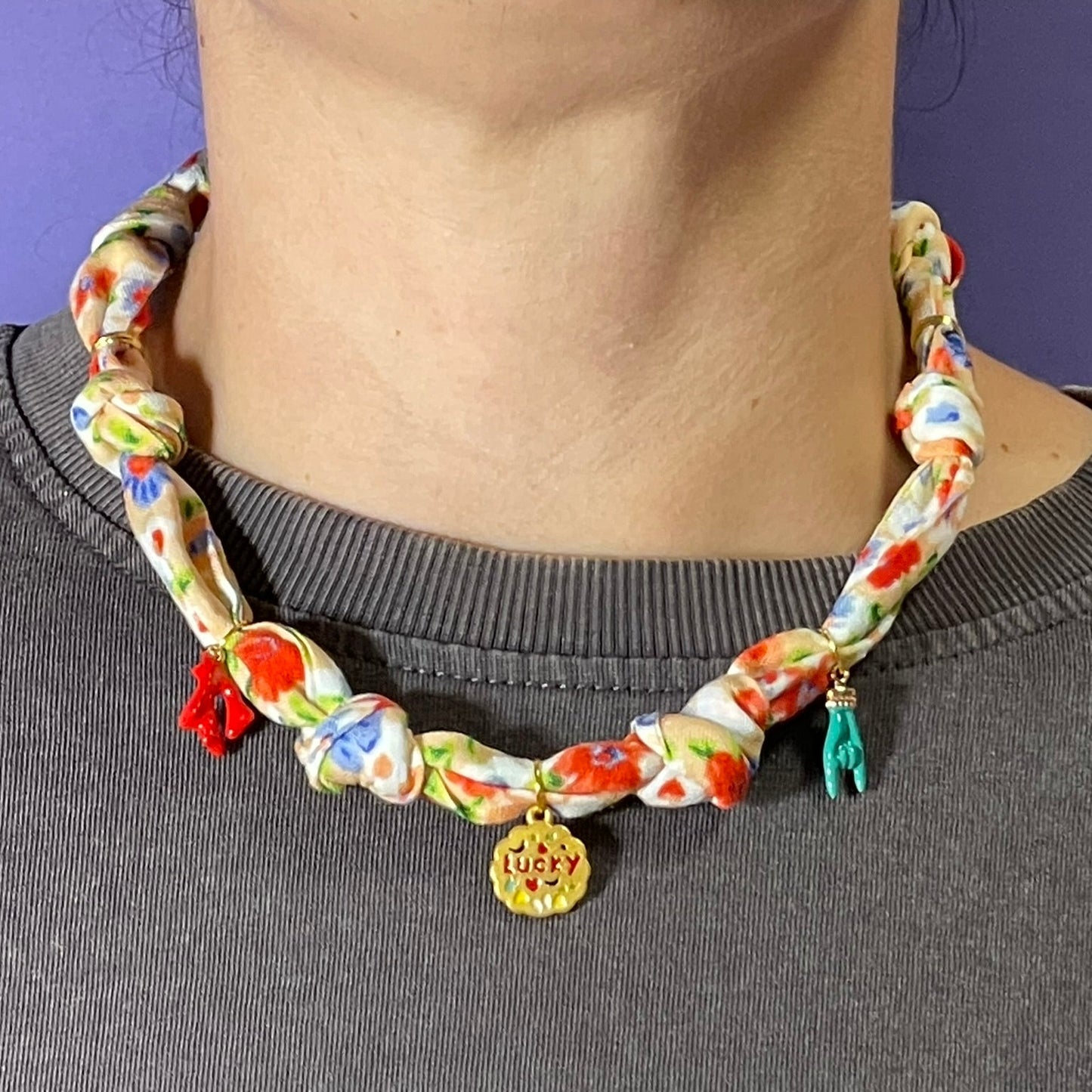 Collar artesanal con dije dorado y pañuelo trenzado, diseño bohemio hecho a mano por Hilma.