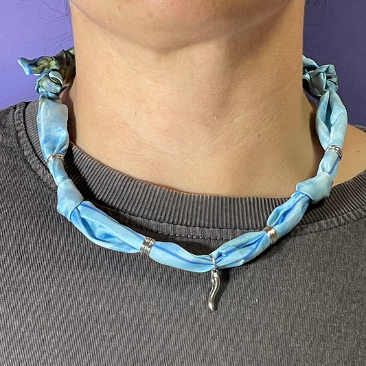 Collar artesanal con dije dorado y pañuelo trenzado, diseño bohemio hecho a mano por Hilma.