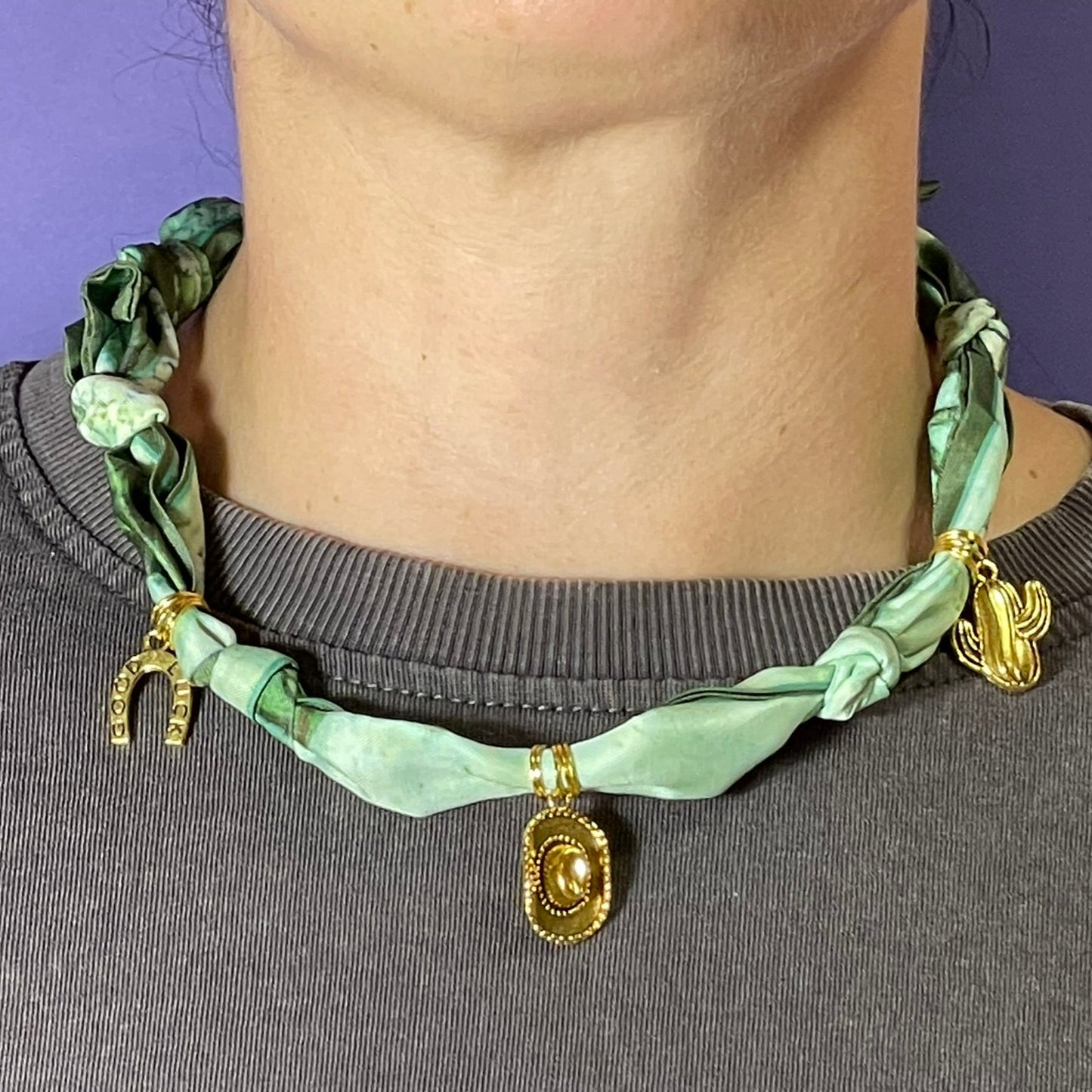 Collar artesanal con dije dorado y pañuelo trenzado, diseño bohemio hecho a mano por Hilma.