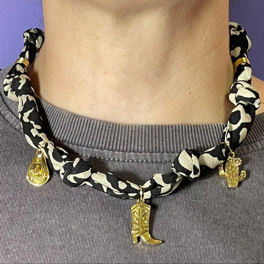 Collar artesanal con dije dorado y pañuelo trenzado, diseño bohemio hecho a mano por Hilma.