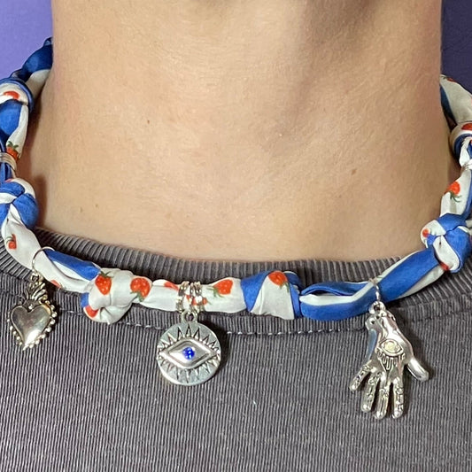 Collar artesanal con dije dorado y pañuelo trenzado, diseño bohemio hecho a mano por Hilma.