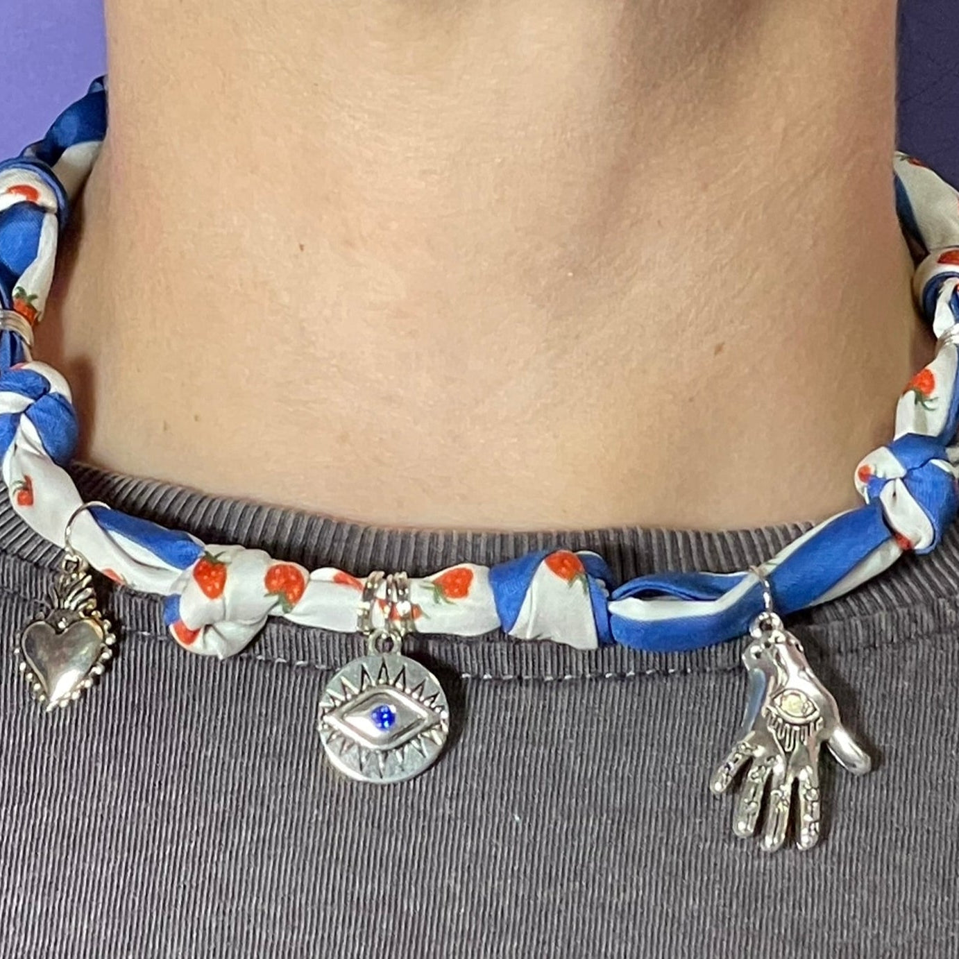 Collar artesanal con dije dorado y pañuelo trenzado, diseño bohemio hecho a mano por Hilma.