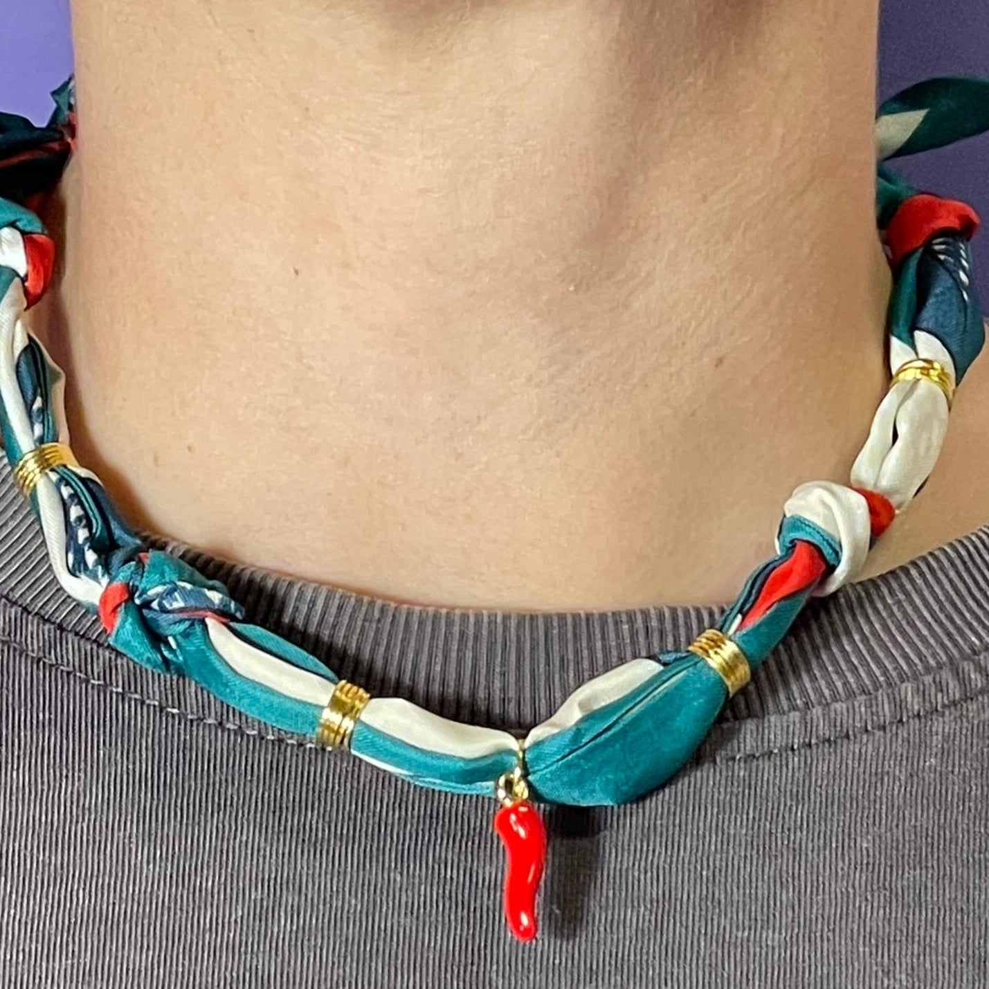 Collar artesanal con dije dorado y pañuelo trenzado, diseño bohemio hecho a mano por Hilma.