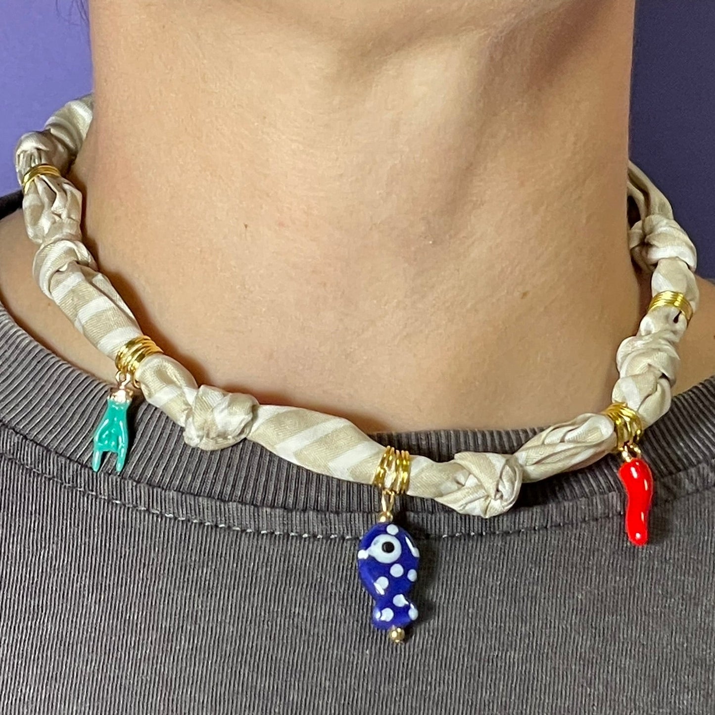 Collar artesanal con dije dorado y pañuelo trenzado, diseño bohemio hecho a mano por Hilma.