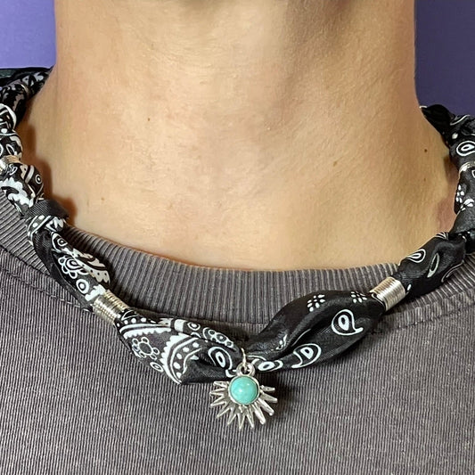 Collar artesanal con dije dorado y pañuelo trenzado, diseño bohemio hecho a mano por Hilma.