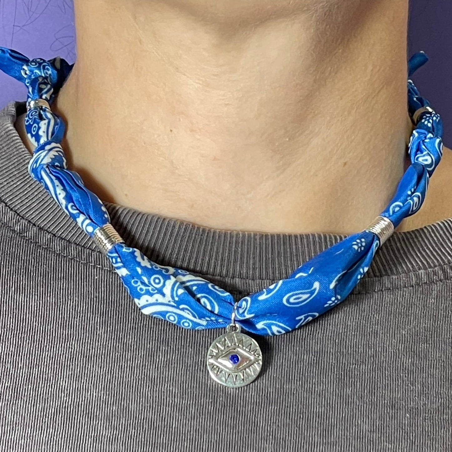 Collar artesanal con dije dorado y pañuelo trenzado, diseño bohemio hecho a mano por Hilma.