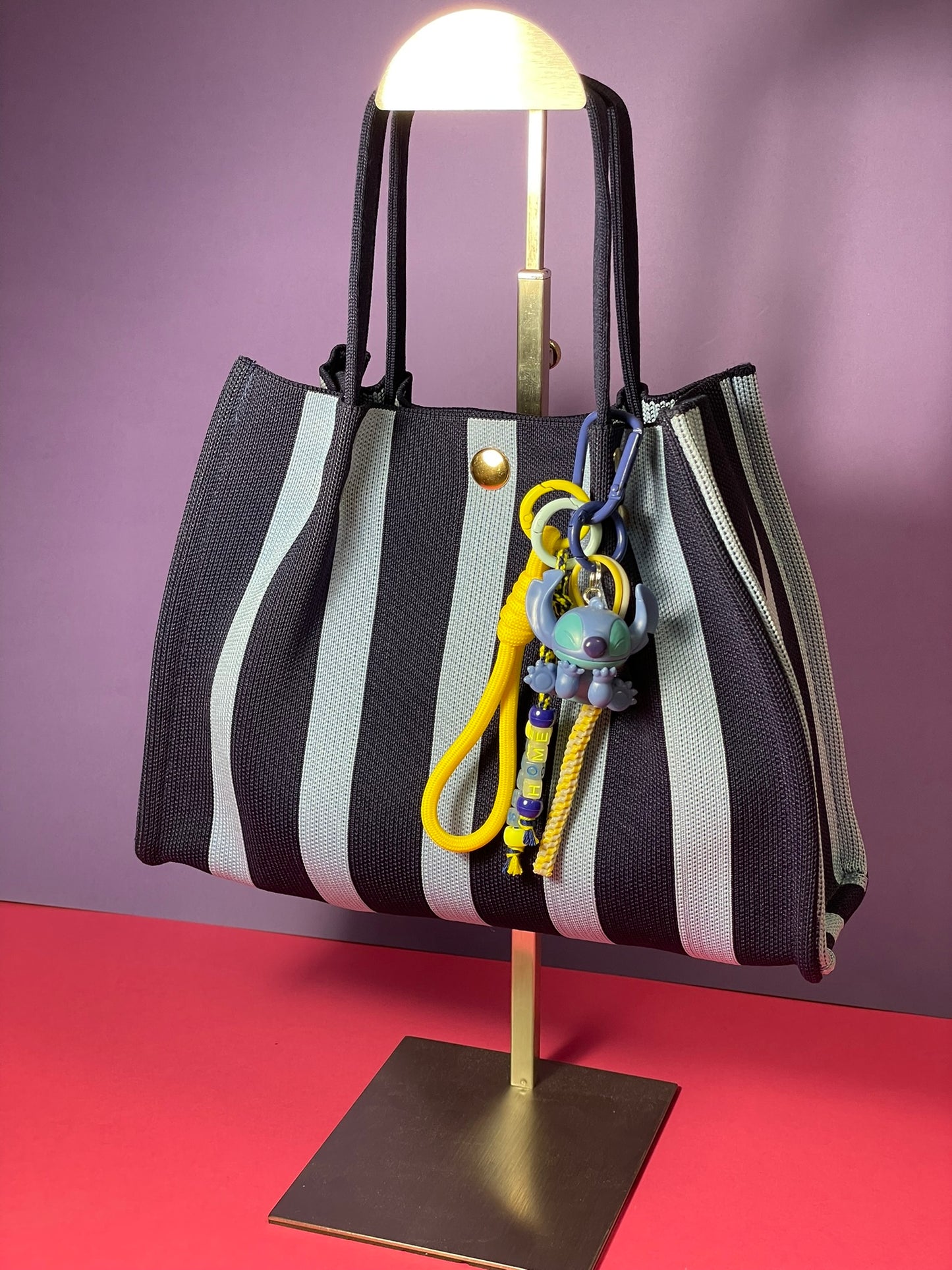 Llavero artesanal colorido con colgantes decorativos y cordones.