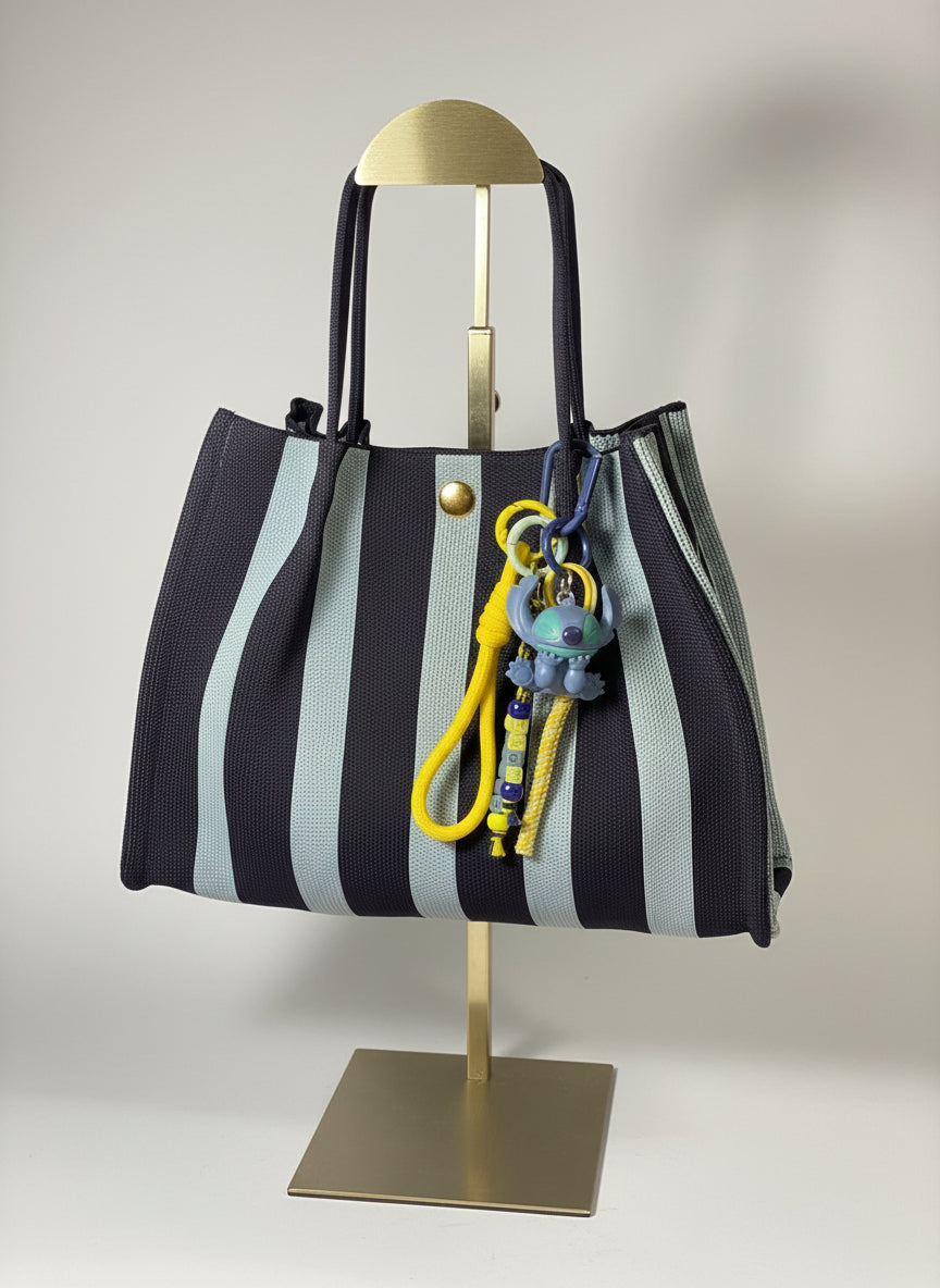 Llavero artesanal colorido con colgantes decorativos y cordones.