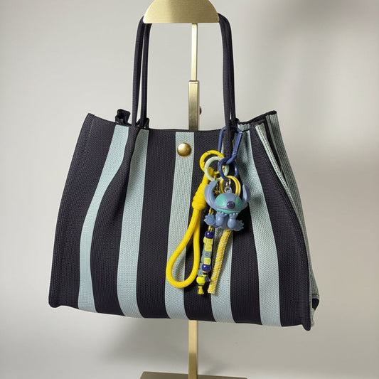 Llavero artesanal colorido con colgantes decorativos y cordones.