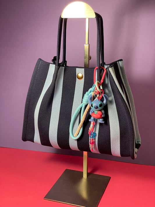 Llavero artesanal colorido con colgantes decorativos y cordones.