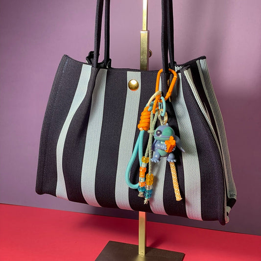 Llavero artesanal colorido con colgantes decorativos y cordones.