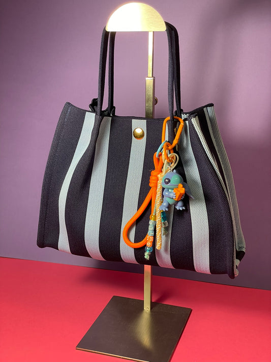 Llavero artesanal colorido con colgantes decorativos y cordones.