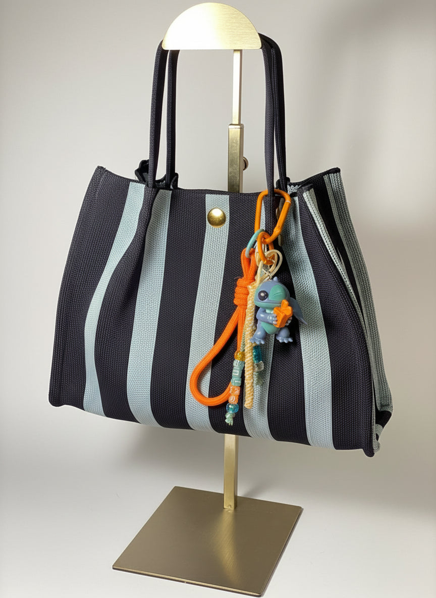 Llavero artesanal colorido con colgantes decorativos y cordones.