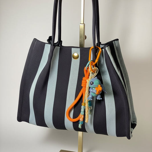 Llavero artesanal colorido con colgantes decorativos y cordones.