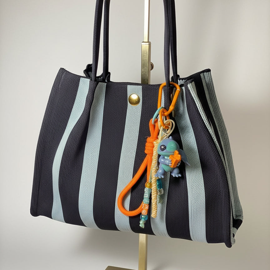 Llavero artesanal colorido con colgantes decorativos y cordones.