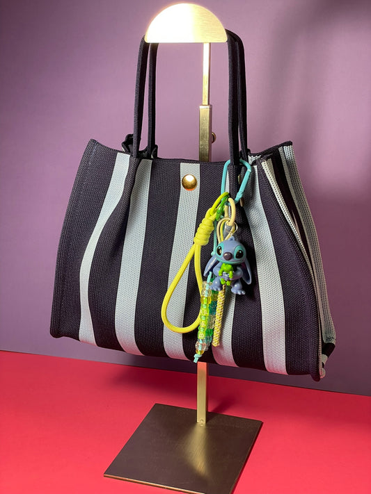 Llavero artesanal colorido con colgantes decorativos y cordones.