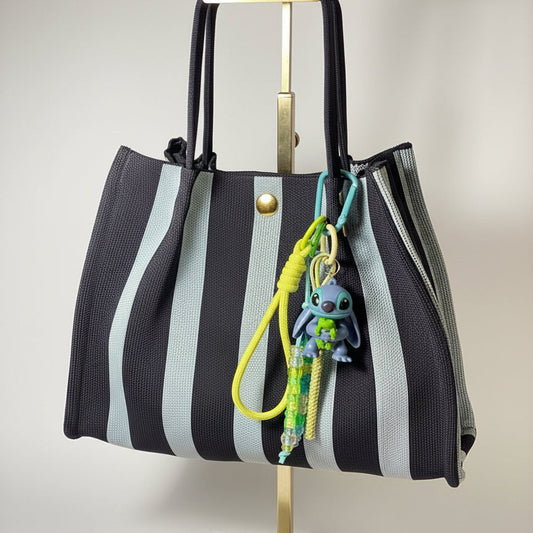 Llavero artesanal colorido con colgantes decorativos y cordones.