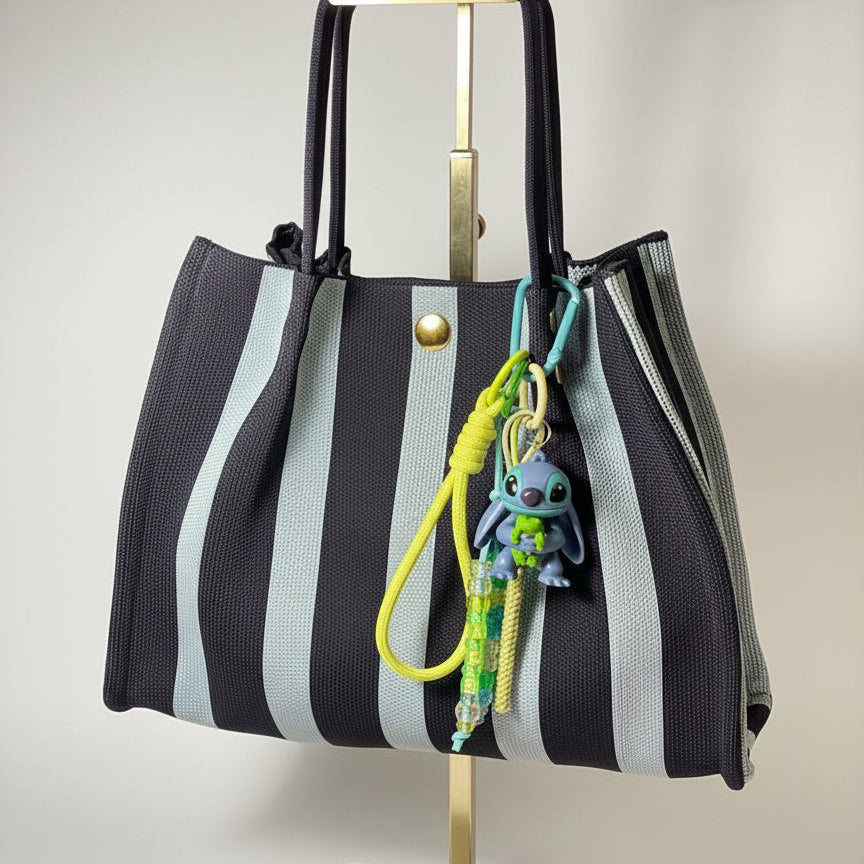 Llavero artesanal colorido con colgantes decorativos y cordones.