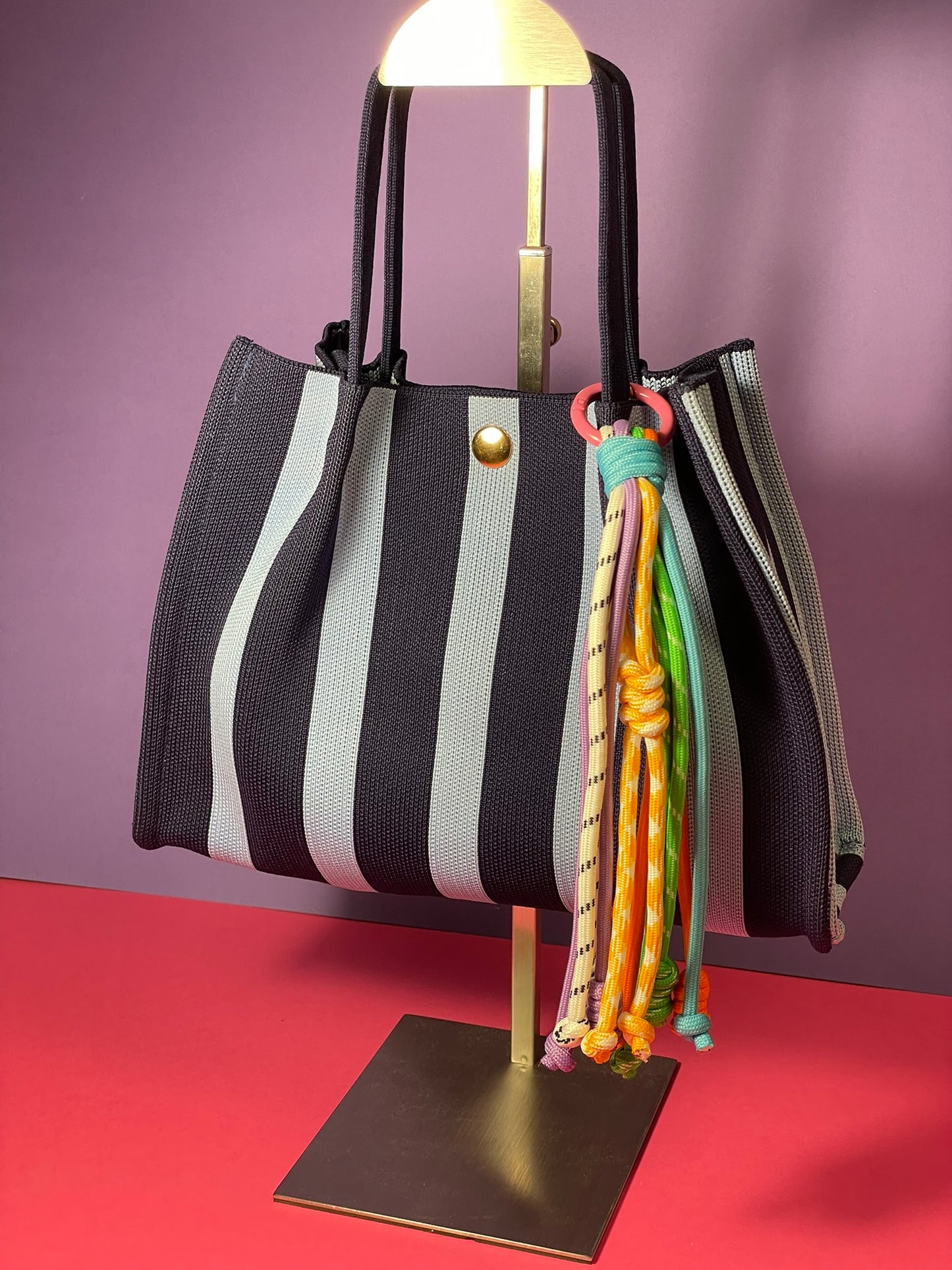 Llavero artesanal colorido con colgantes decorativos y cordones.