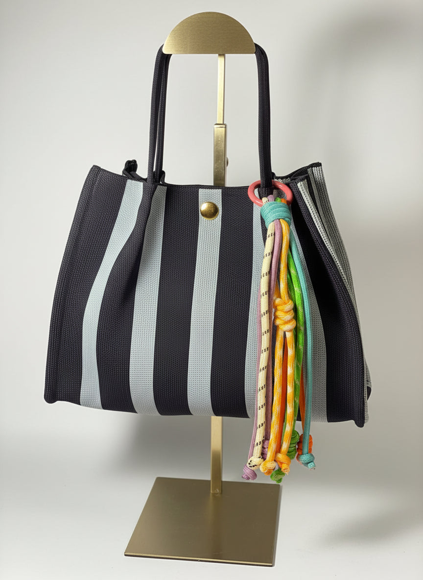 Llavero artesanal colorido con colgantes decorativos y cordones.