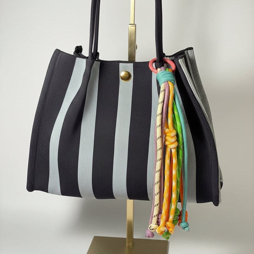 Llavero artesanal colorido con colgantes decorativos y cordones.