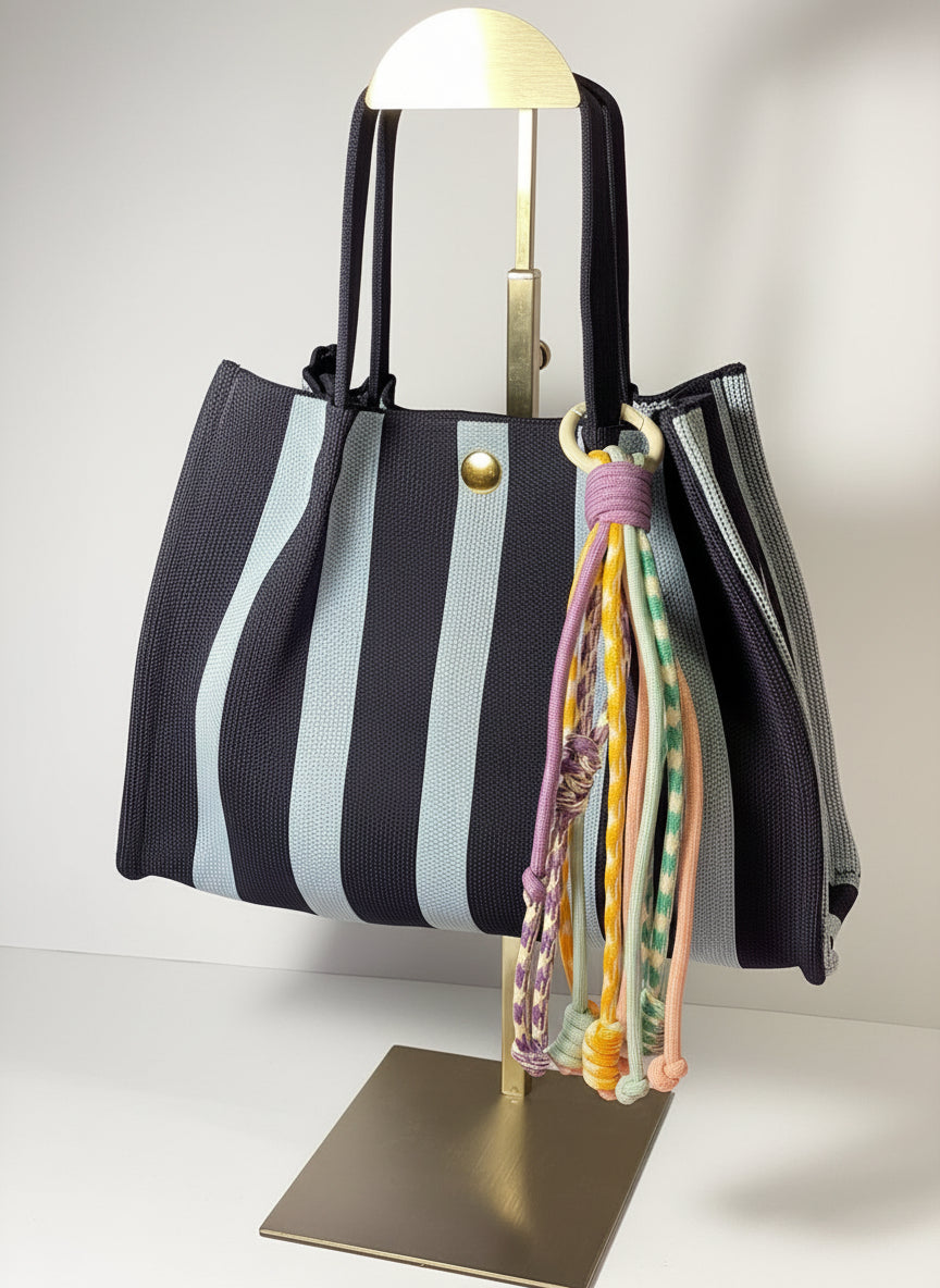 Llavero artesanal colorido con colgantes decorativos y cordones.