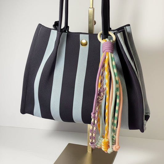 Llavero artesanal colorido con colgantes decorativos y cordones.