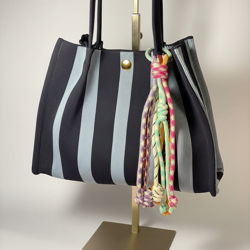 Llavero artesanal colorido con colgantes decorativos y cordones.