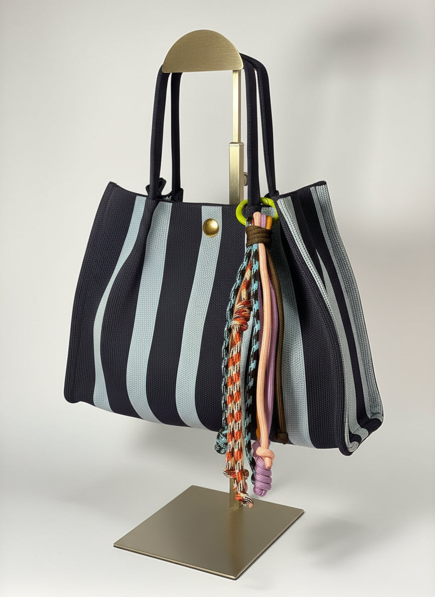 Llavero artesanal colorido con colgantes decorativos y cordones.