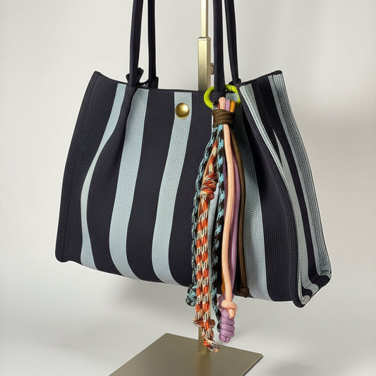 Llavero artesanal colorido con colgantes decorativos y cordones.