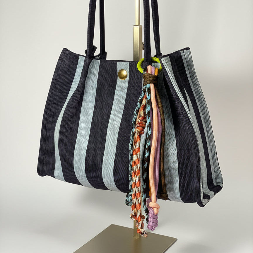 Llavero artesanal colorido con colgantes decorativos y cordones.