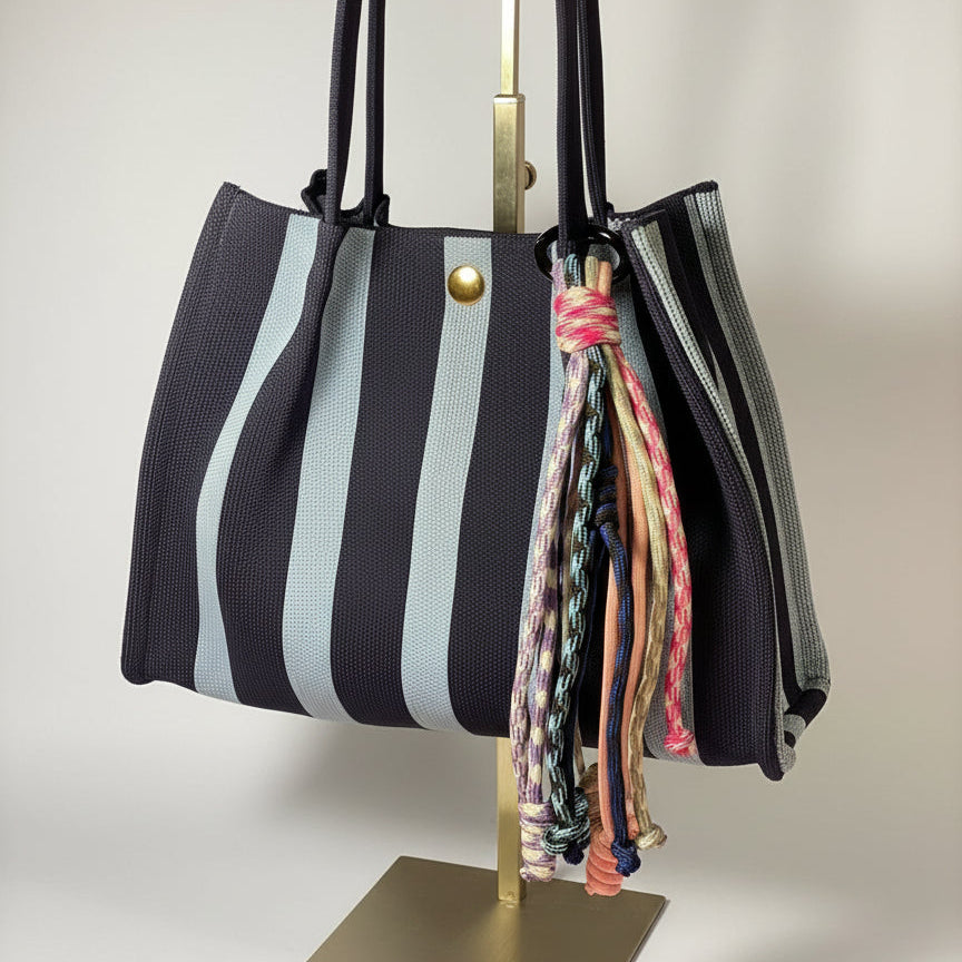 Llavero artesanal colorido con colgantes decorativos y cordones.