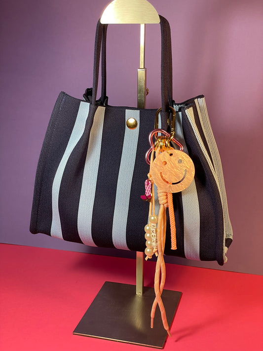 Llavero artesanal colorido con colgantes decorativos y cordones.