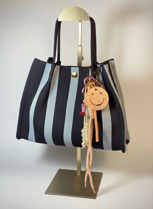 Llavero artesanal colorido con colgantes decorativos y cordones.