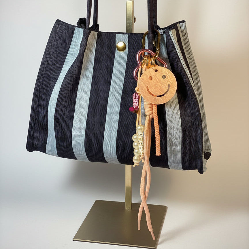 Llavero artesanal colorido con colgantes decorativos y cordones.