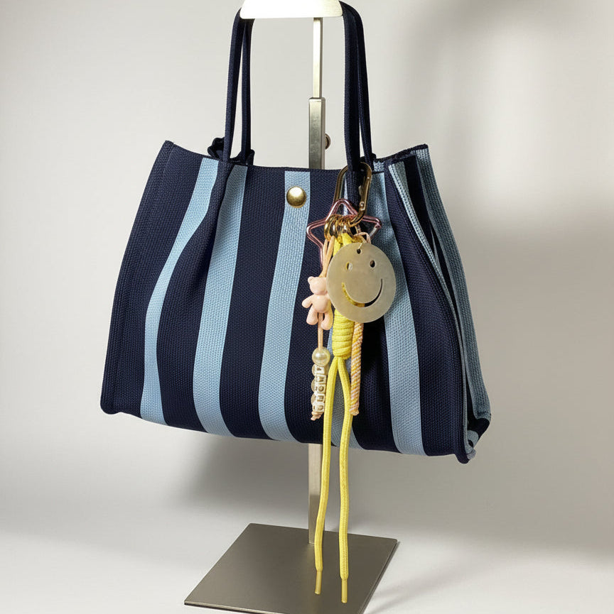 Llavero artesanal colorido con colgantes decorativos y cordones.