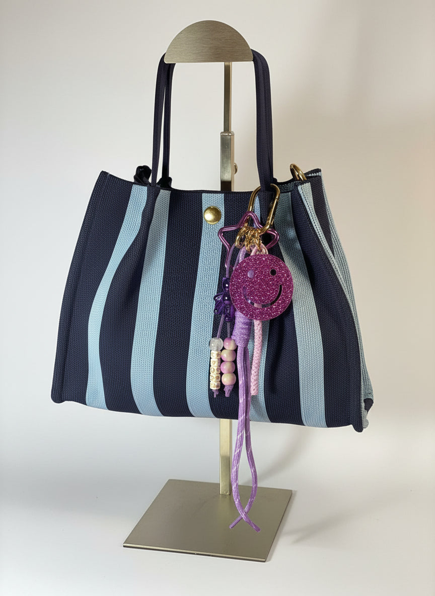 Llavero artesanal colorido con colgantes decorativos y cordones.