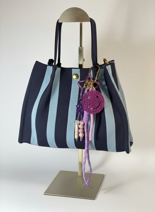 Llavero artesanal colorido con colgantes decorativos y cordones.