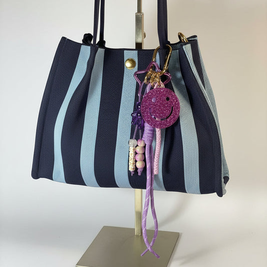 Llavero artesanal colorido con colgantes decorativos y cordones.