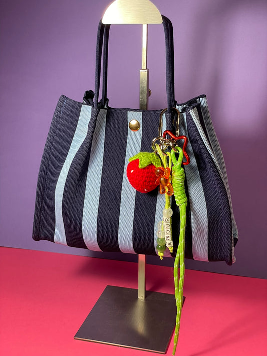 Llavero artesanal colorido con colgantes decorativos y cordones.