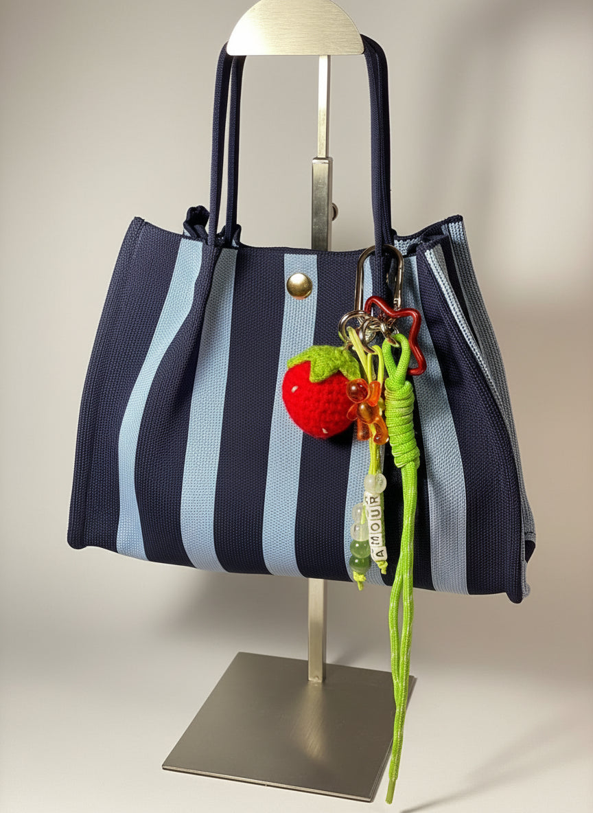 Llavero artesanal colorido con colgantes decorativos y cordones.