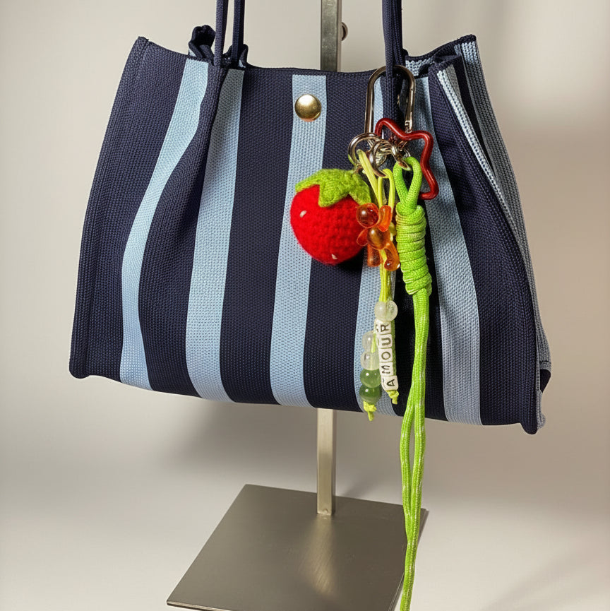 Llavero artesanal colorido con colgantes decorativos y cordones.