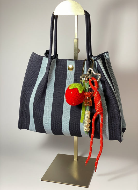 Llavero artesanal colorido con colgantes decorativos y cordones.