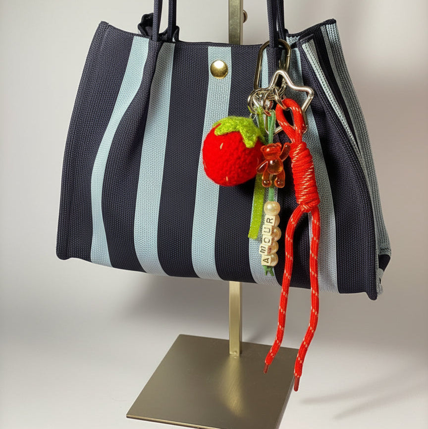 Llavero artesanal colorido con colgantes decorativos y cordones.