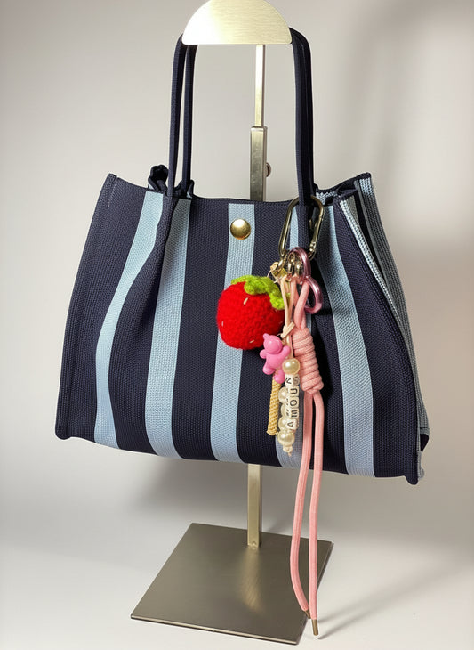 Llavero artesanal colorido con colgantes decorativos y cordones.