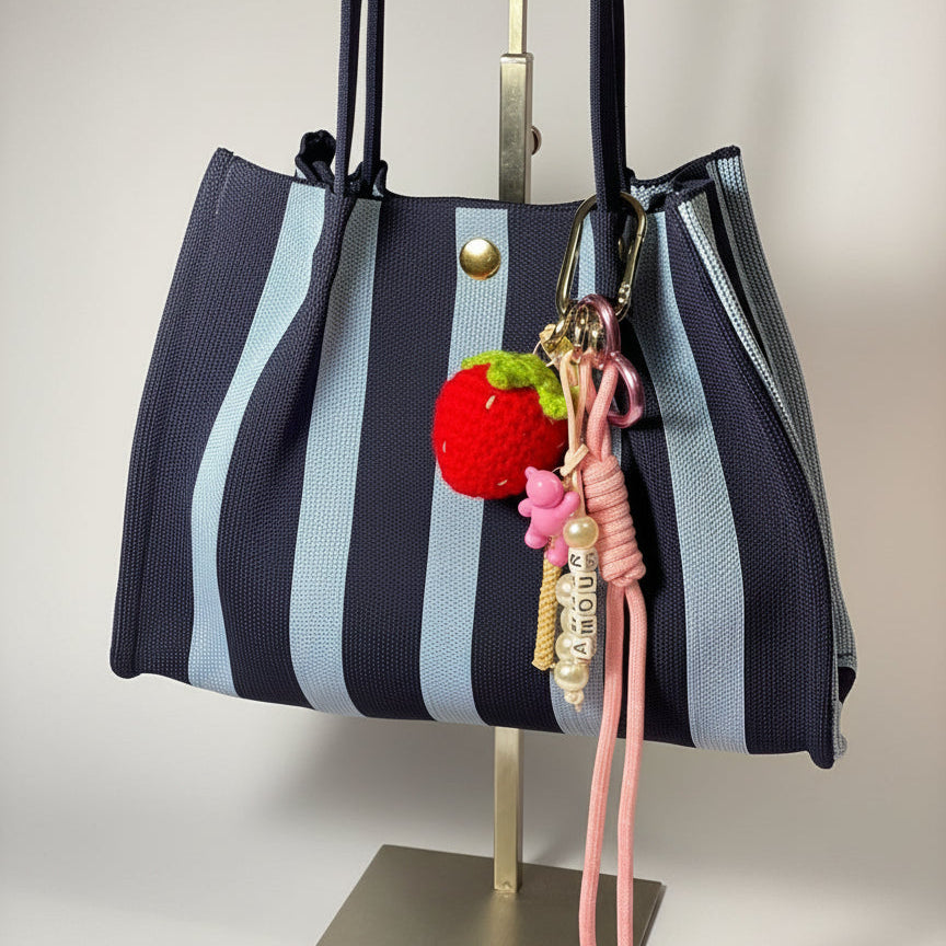 Llavero artesanal colorido con colgantes decorativos y cordones.