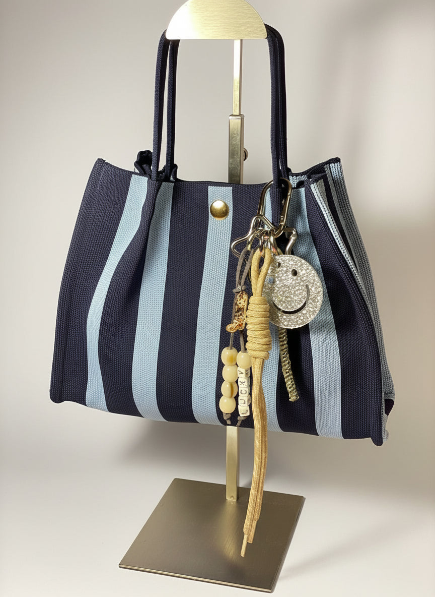 Llavero artesanal colorido con colgantes decorativos y cordones.