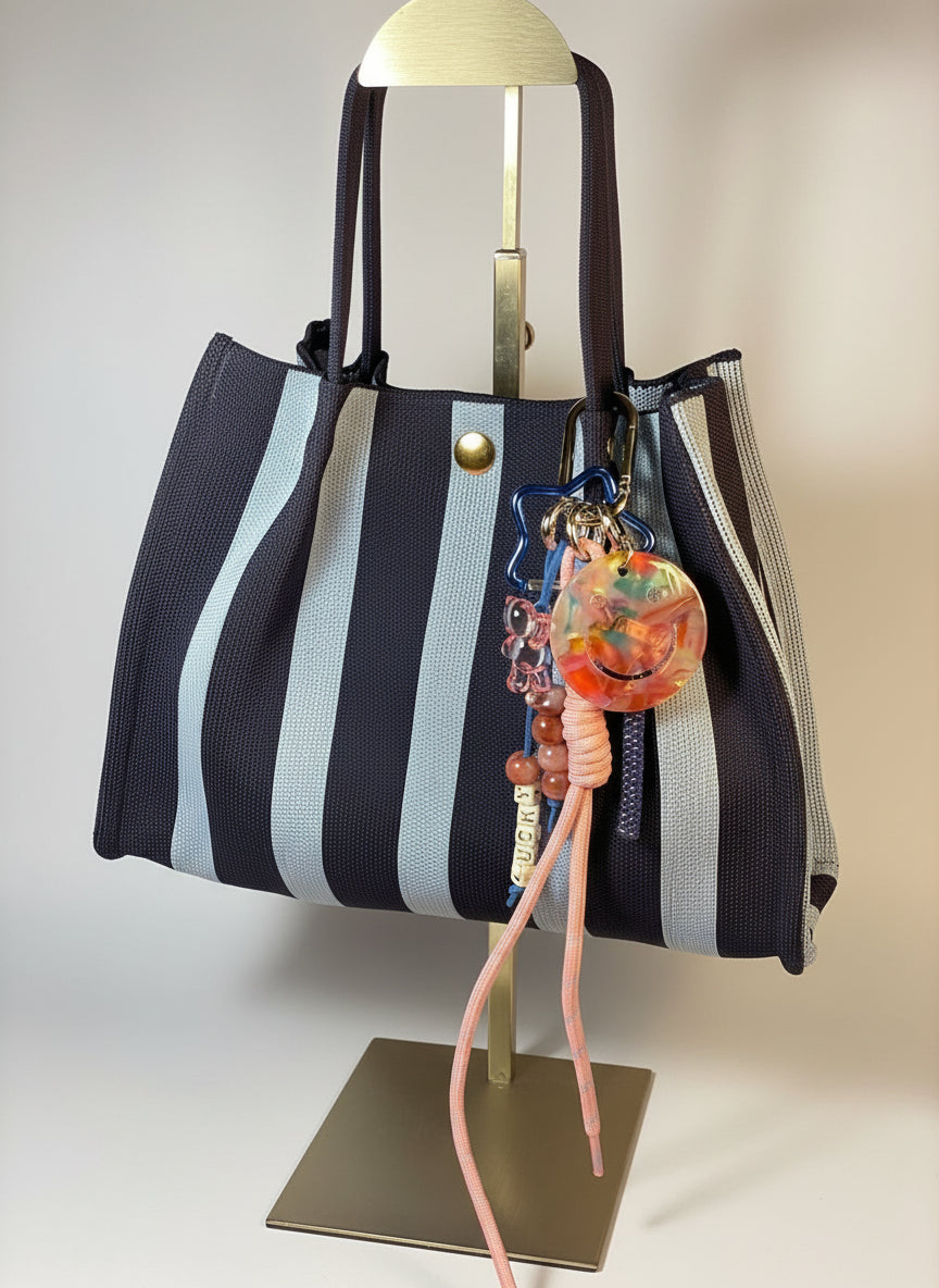 Llavero artesanal colorido con colgantes decorativos y cordones.