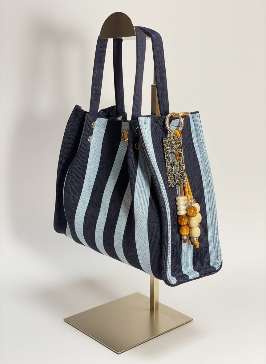 Llavero artesanal colorido con colgantes decorativos y cordones.