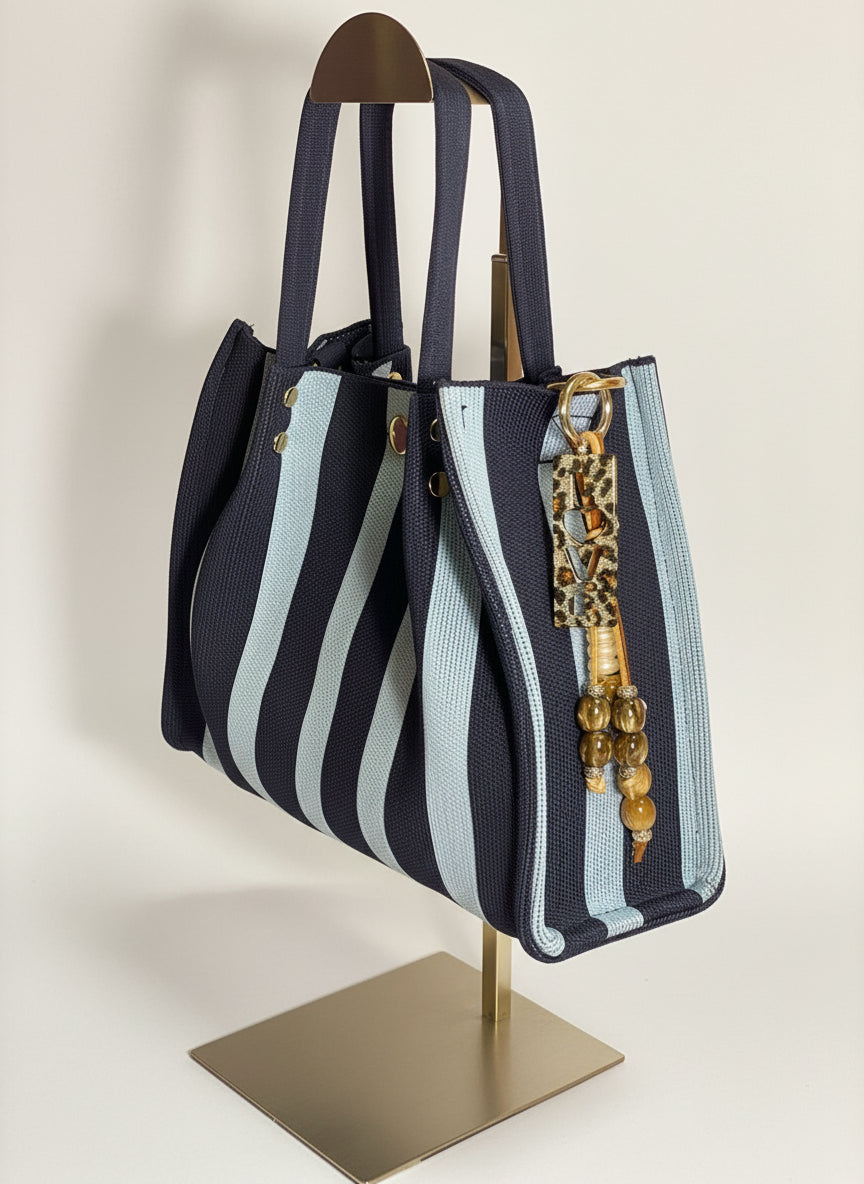 Llavero artesanal colorido con colgantes decorativos y cordones.